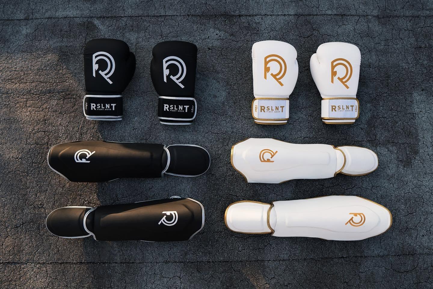 Black and white RSLNT hand wraps and protective gear arranged as a product system.
